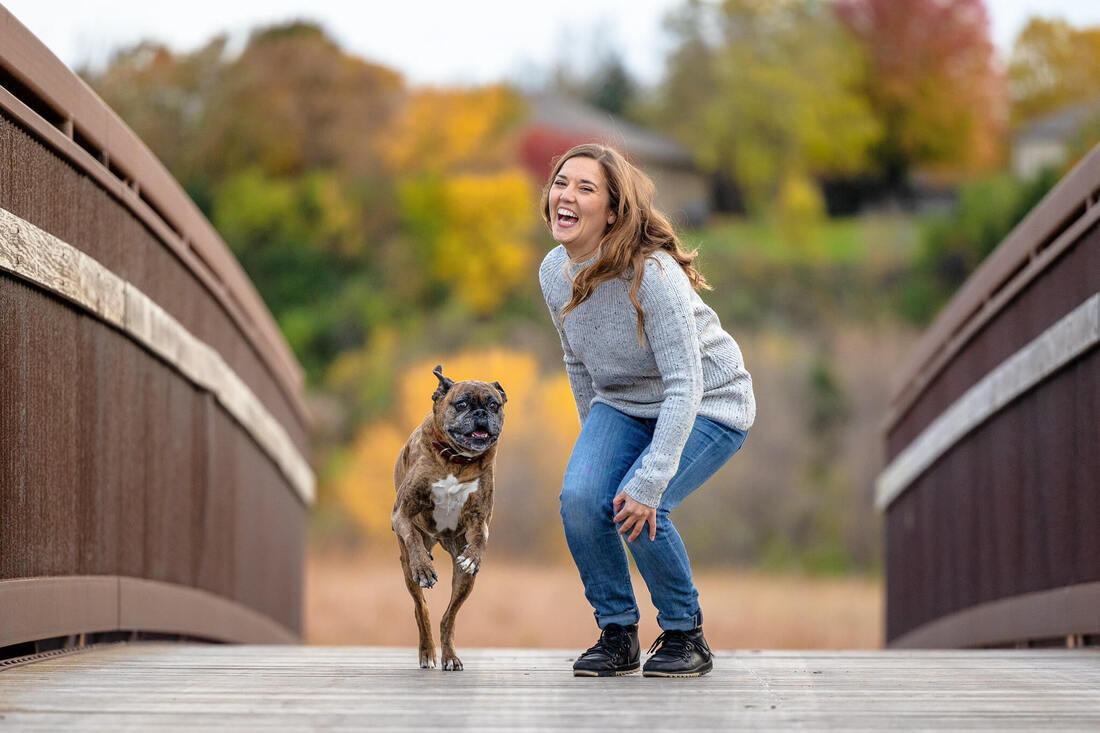 brindle boxer dog running on bridge with dog mom
